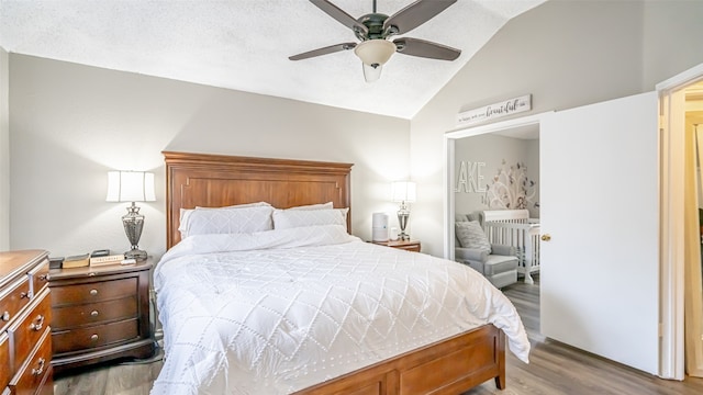 bedroom featuring ceiling fan, light hardwood / wood-style floors, and lofted ceiling