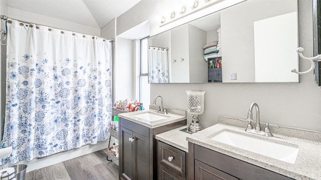 bathroom featuring a textured ceiling, wood-type flooring, and vanity