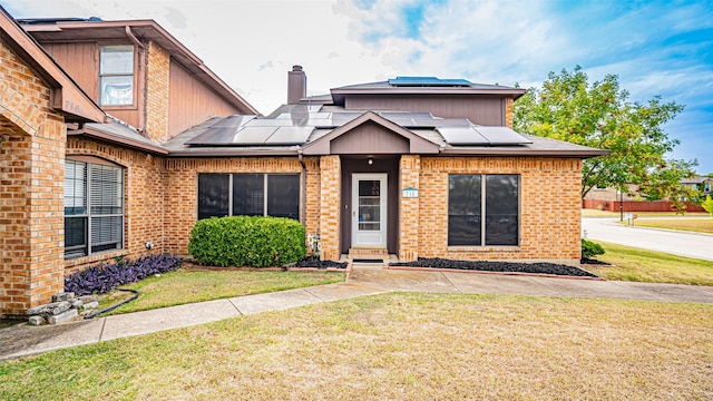 view of front of house featuring a front lawn and solar panels