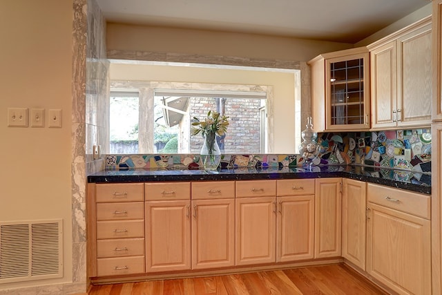 kitchen with light brown cabinetry, backsplash, and light hardwood / wood-style floors