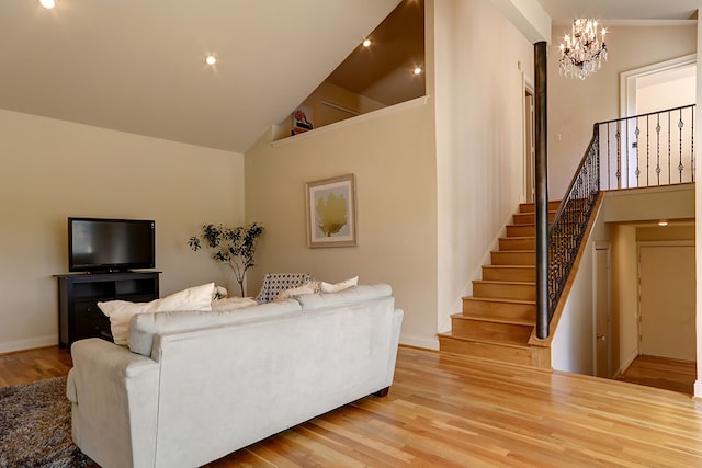 living room featuring high vaulted ceiling, an inviting chandelier, and light hardwood / wood-style flooring