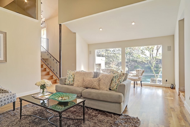 living room with hardwood / wood-style floors and high vaulted ceiling