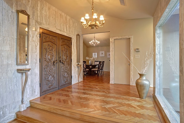 foyer with tile walls, a chandelier, parquet flooring, and vaulted ceiling