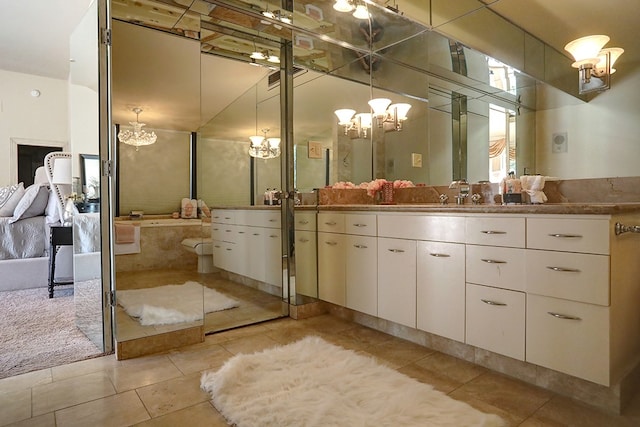 bathroom with vanity, a notable chandelier, tile patterned floors, and a relaxing tiled tub