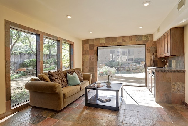 living room featuring tile walls and sink