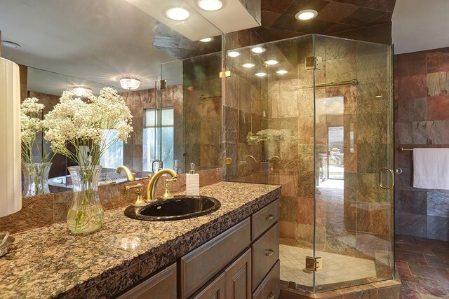 bathroom with vanity and a shower with door