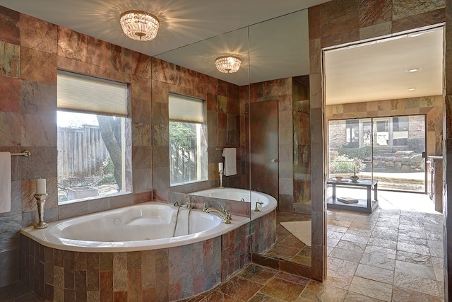 bathroom with tile walls and separate shower and tub