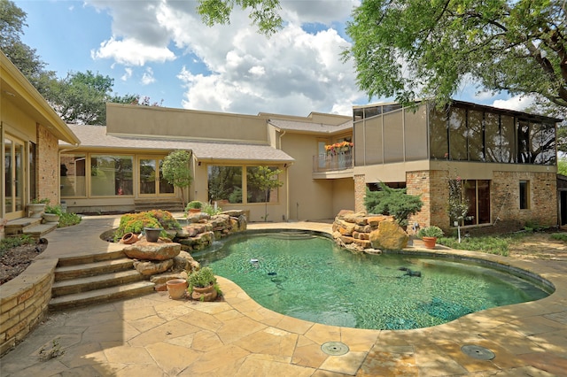 view of swimming pool with a patio area and a sunroom