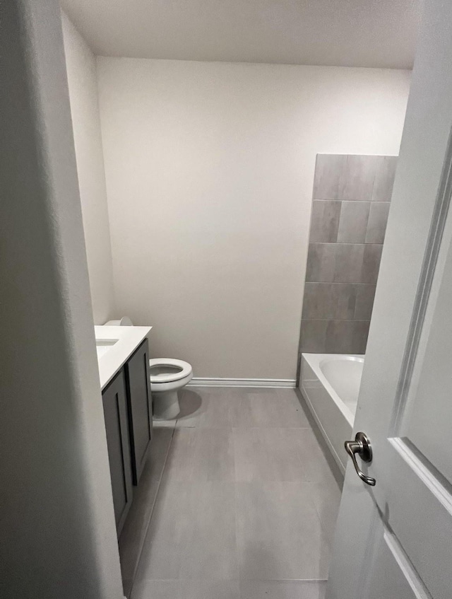 bathroom with a bath, tile patterned floors, toilet, baseboards, and vanity