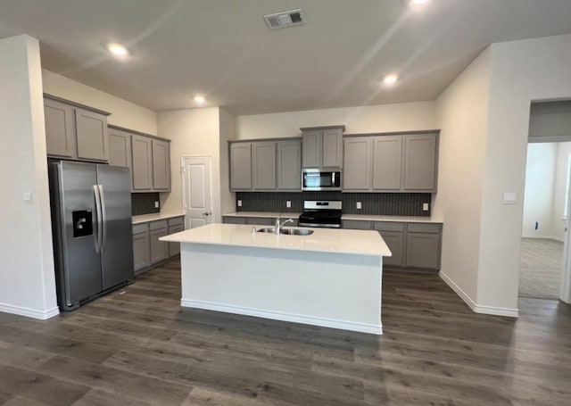 kitchen with recessed lighting, gray cabinets, a sink, tasteful backsplash, and appliances with stainless steel finishes