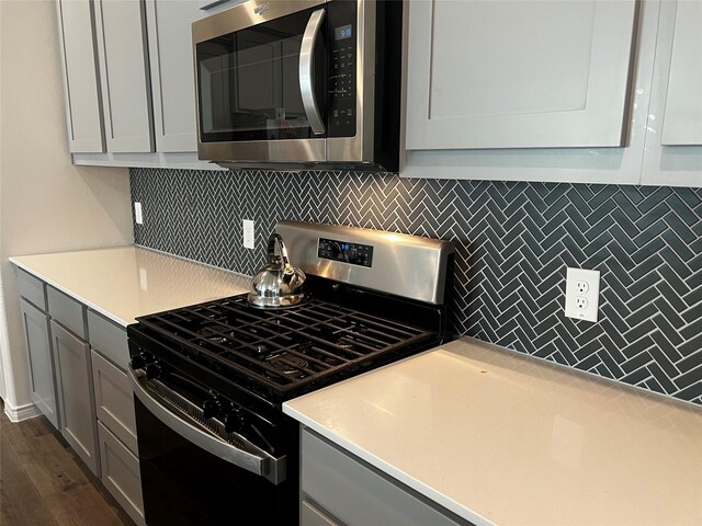 2000 Stinnet St, Anna, TX 75409 - kitchen featuring appliances with stainless steel finishes, gray cabinetry, tasteful backsplash, and light countertops