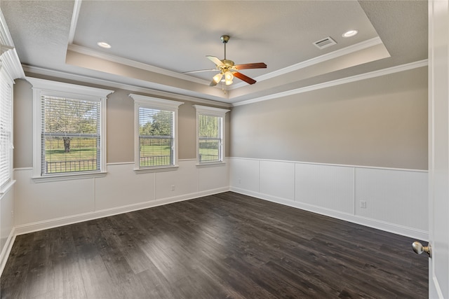 unfurnished room with ceiling fan, a raised ceiling, ornamental molding, a textured ceiling, and dark hardwood / wood-style floors