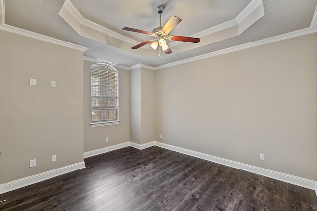 empty room featuring ceiling fan, ornamental molding, dark hardwood / wood-style flooring, and a tray ceiling