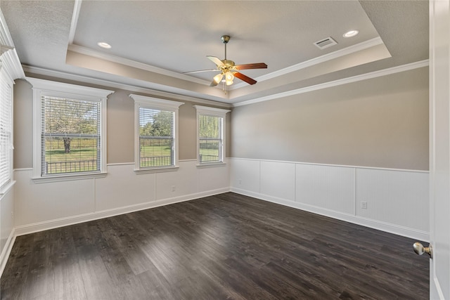 unfurnished room featuring dark hardwood / wood-style floors, a textured ceiling, ceiling fan, and a tray ceiling