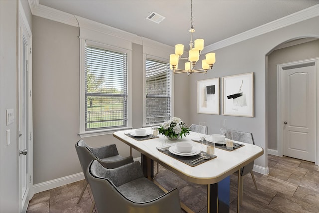 dining space with crown molding and an inviting chandelier