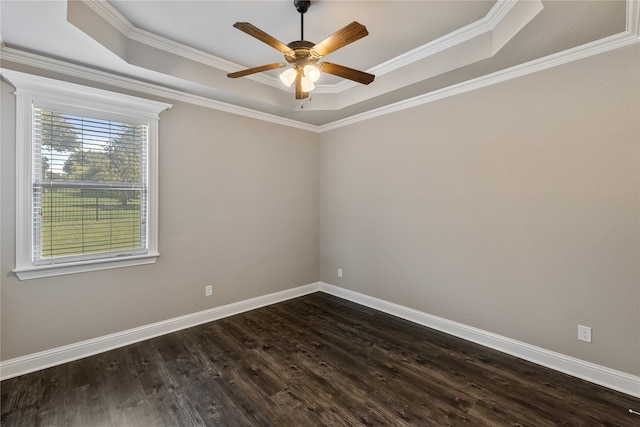 spare room with a healthy amount of sunlight, a tray ceiling, dark hardwood / wood-style floors, and ceiling fan