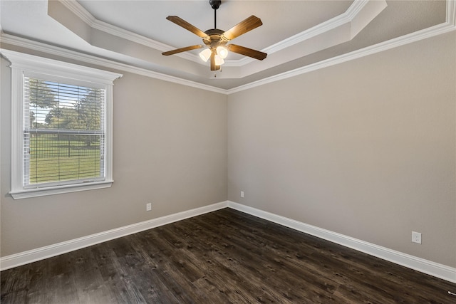 empty room featuring crown molding, ceiling fan, dark hardwood / wood-style flooring, and a raised ceiling