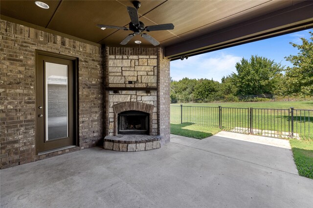 view of patio / terrace featuring a large fireplace and ceiling fan