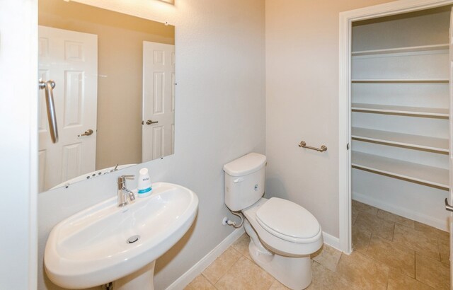 bathroom with tile patterned flooring, toilet, and sink