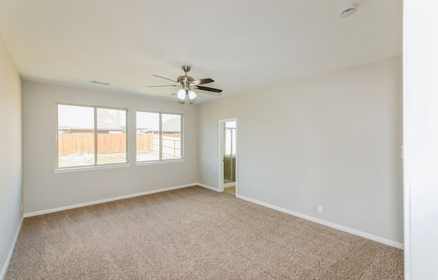 carpeted spare room featuring ceiling fan