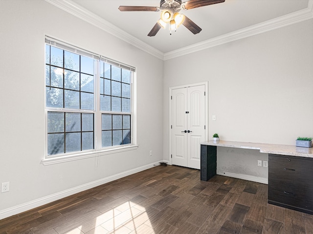 unfurnished office featuring crown molding, built in desk, ceiling fan, and dark hardwood / wood-style floors