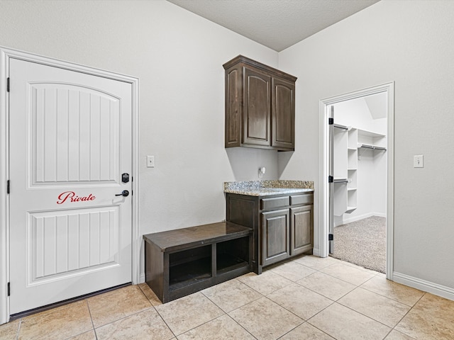 mudroom featuring light tile patterned floors and a textured ceiling