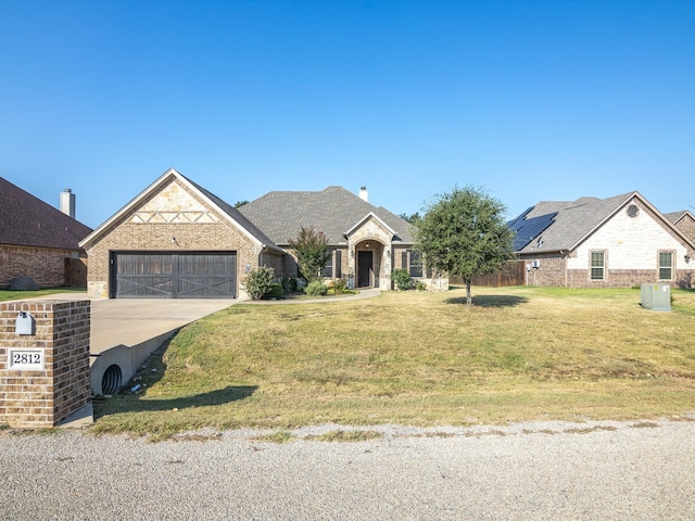 view of front of property featuring a front yard and a garage