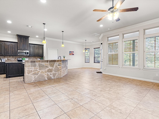 kitchen featuring appliances with stainless steel finishes, a healthy amount of sunlight, light stone counters, and ceiling fan