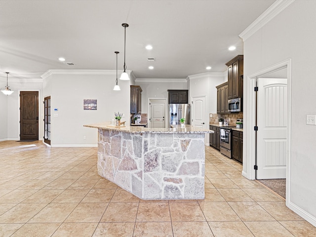 kitchen featuring decorative light fixtures, light tile patterned floors, stainless steel appliances, and a center island with sink