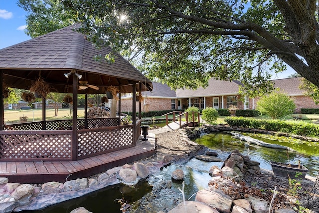 surrounding community featuring a gazebo, a small pond, and a deck