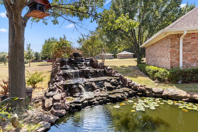 view of yard featuring a small pond