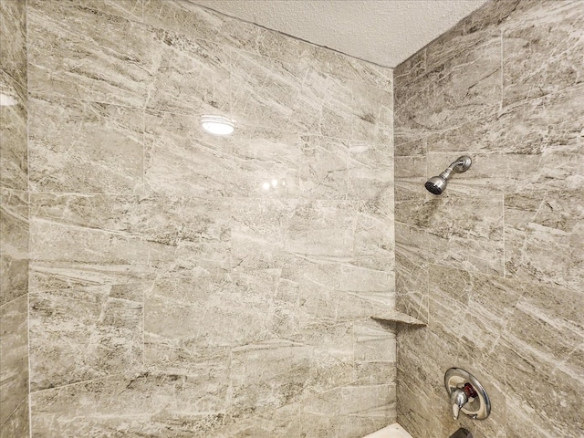 details with a textured ceiling and a tile shower