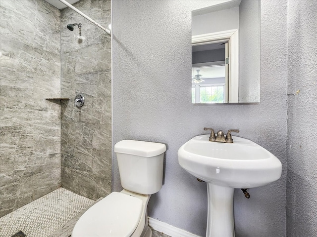 bathroom featuring toilet and a tile shower