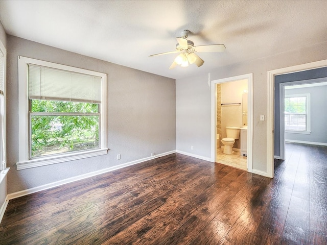 empty room with a textured ceiling, dark wood-type flooring, and ceiling fan