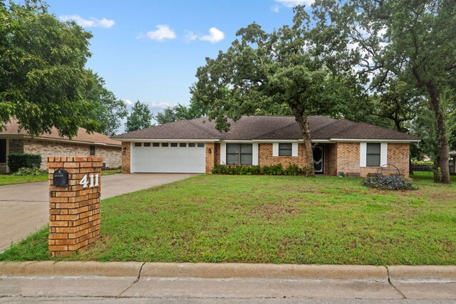 ranch-style house with a garage and a front lawn