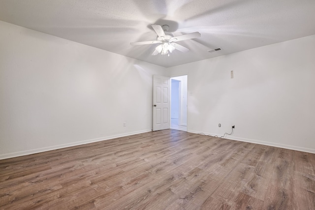 unfurnished room with light hardwood / wood-style floors, ceiling fan, and a textured ceiling