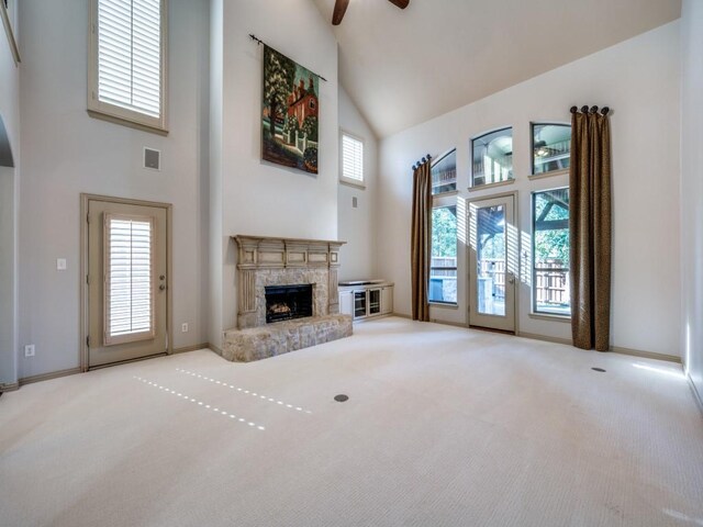 unfurnished living room with carpet flooring, high vaulted ceiling, and ceiling fan