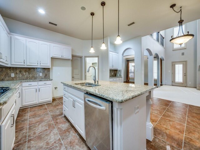 kitchen featuring a kitchen island with sink, stainless steel dishwasher, sink, decorative backsplash, and white cabinets