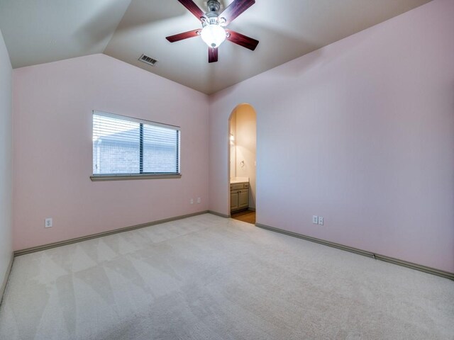 carpeted spare room featuring lofted ceiling and ceiling fan