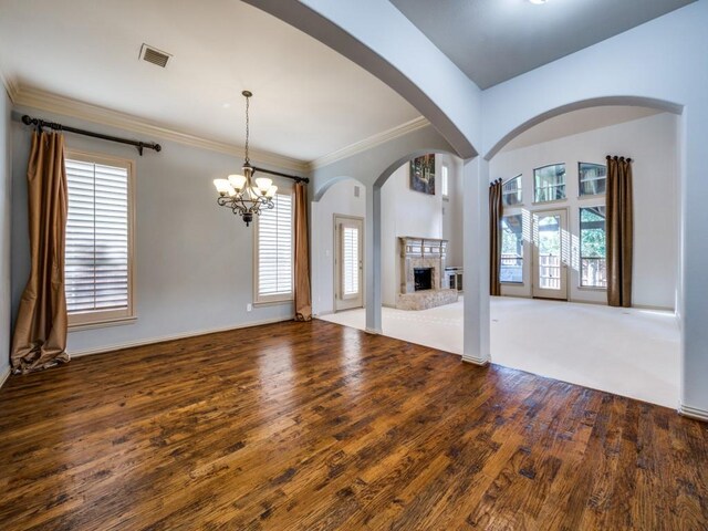 unfurnished living room featuring crown molding, an inviting chandelier, and hardwood / wood-style flooring