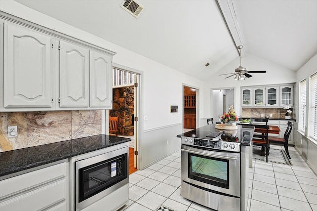 kitchen with white cabinets, ceiling fan, stainless steel appliances, and lofted ceiling with beams