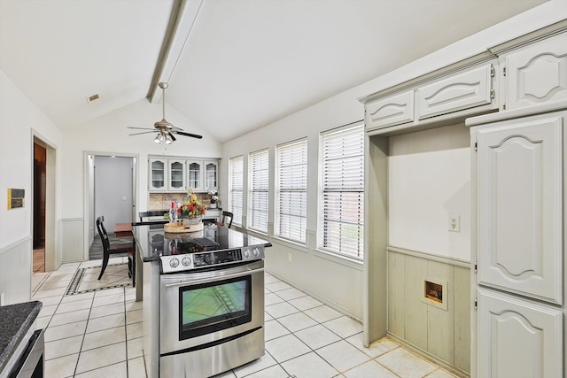 kitchen with ceiling fan, appliances with stainless steel finishes, white cabinetry, and lofted ceiling with beams