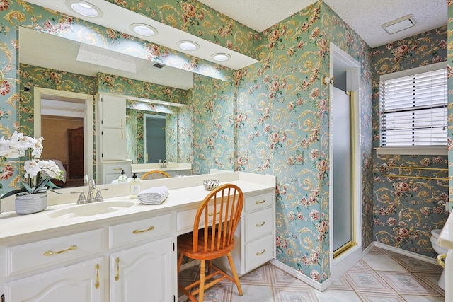 bathroom featuring vanity, a textured ceiling, toilet, and walk in shower