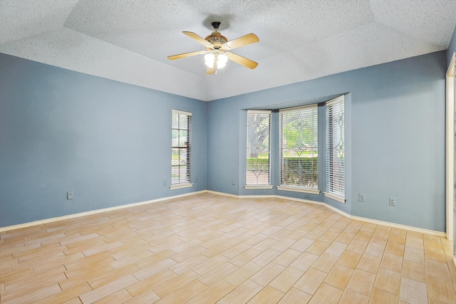 empty room featuring lofted ceiling, ceiling fan, and light hardwood / wood-style floors