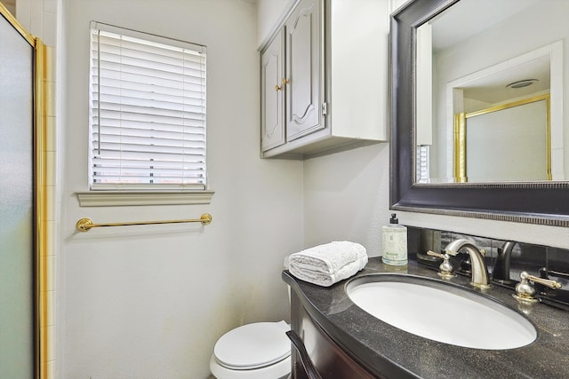 bathroom featuring walk in shower, toilet, and vanity