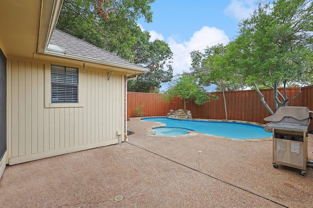 view of swimming pool with grilling area and a patio