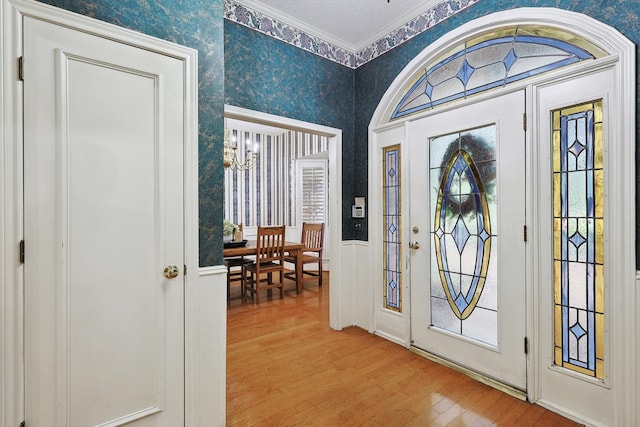 entrance foyer with light wood-type flooring and crown molding