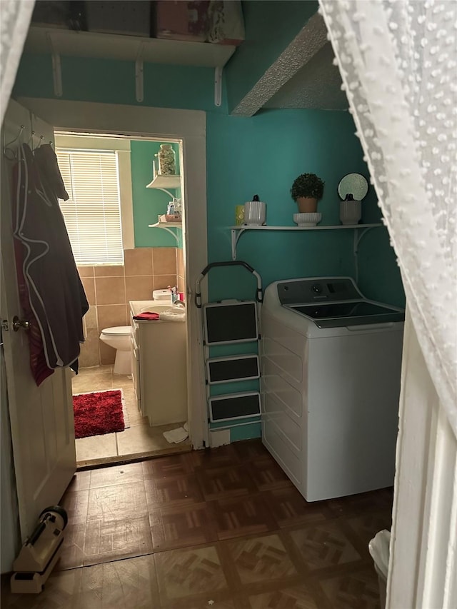 clothes washing area with tile walls and washer / clothes dryer