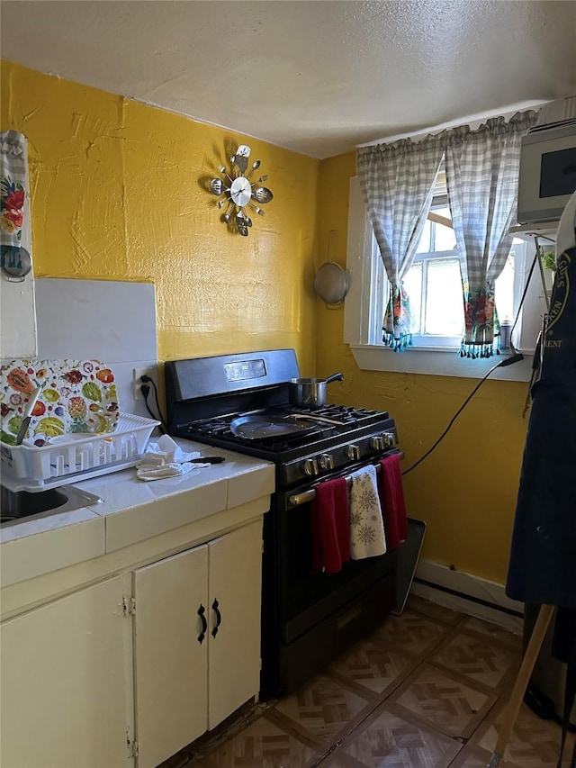 kitchen with tile countertops and black gas range