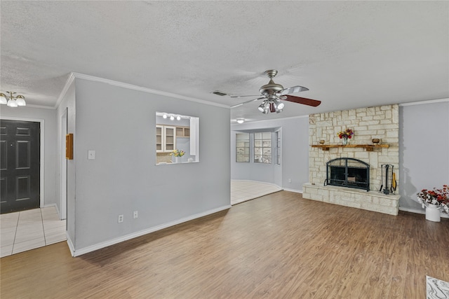 unfurnished living room with ceiling fan, a fireplace, wood-type flooring, and a textured ceiling